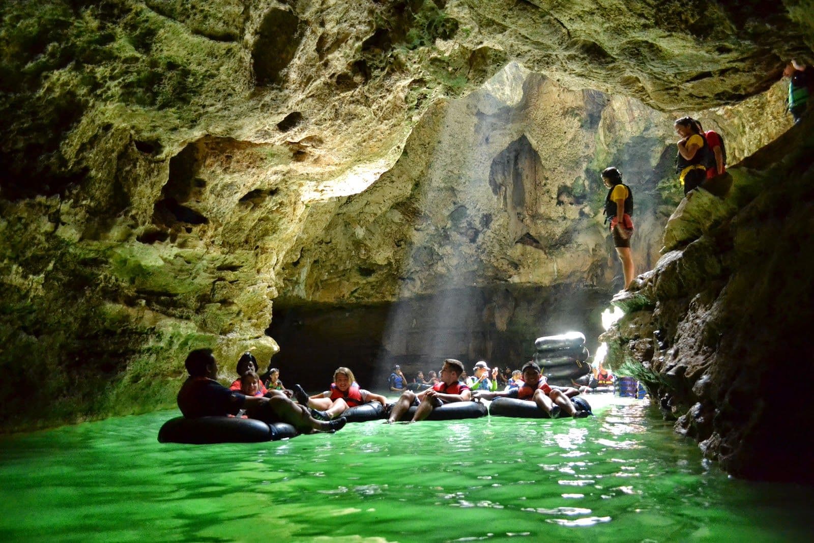 Visitors floating on inner tubes through the rocky interior of Goa Pindul.