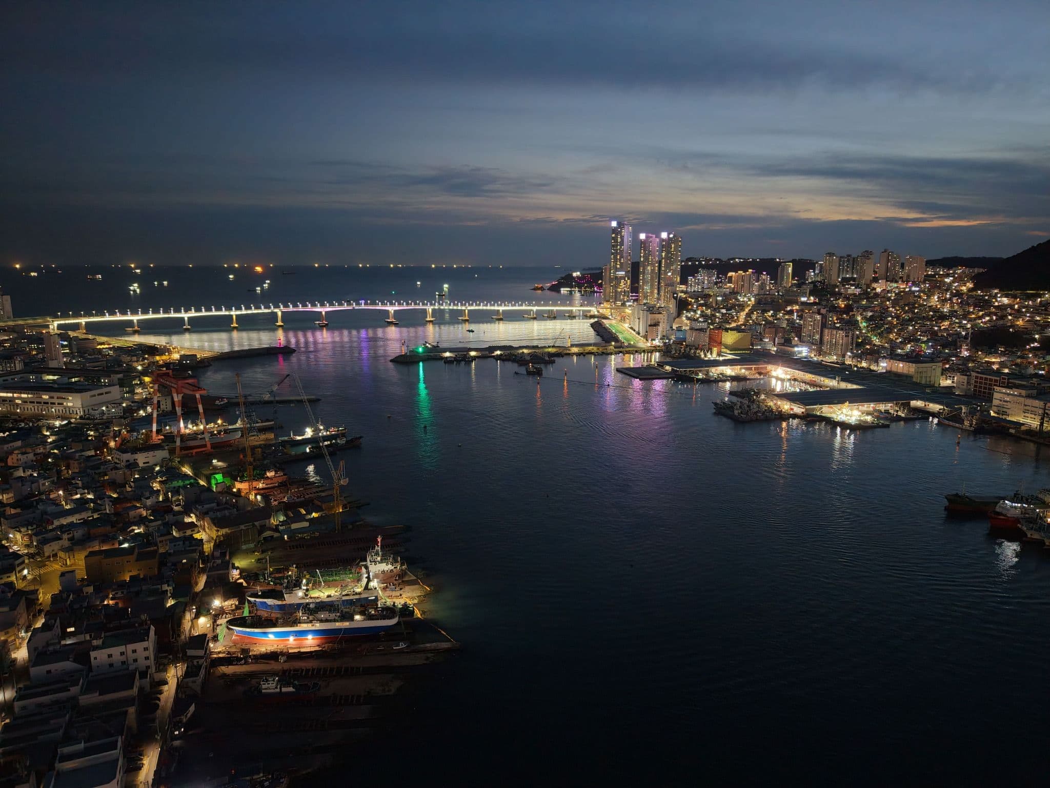 Busan coastal skyline and illuminated bridge overlooking the harbor at dusk