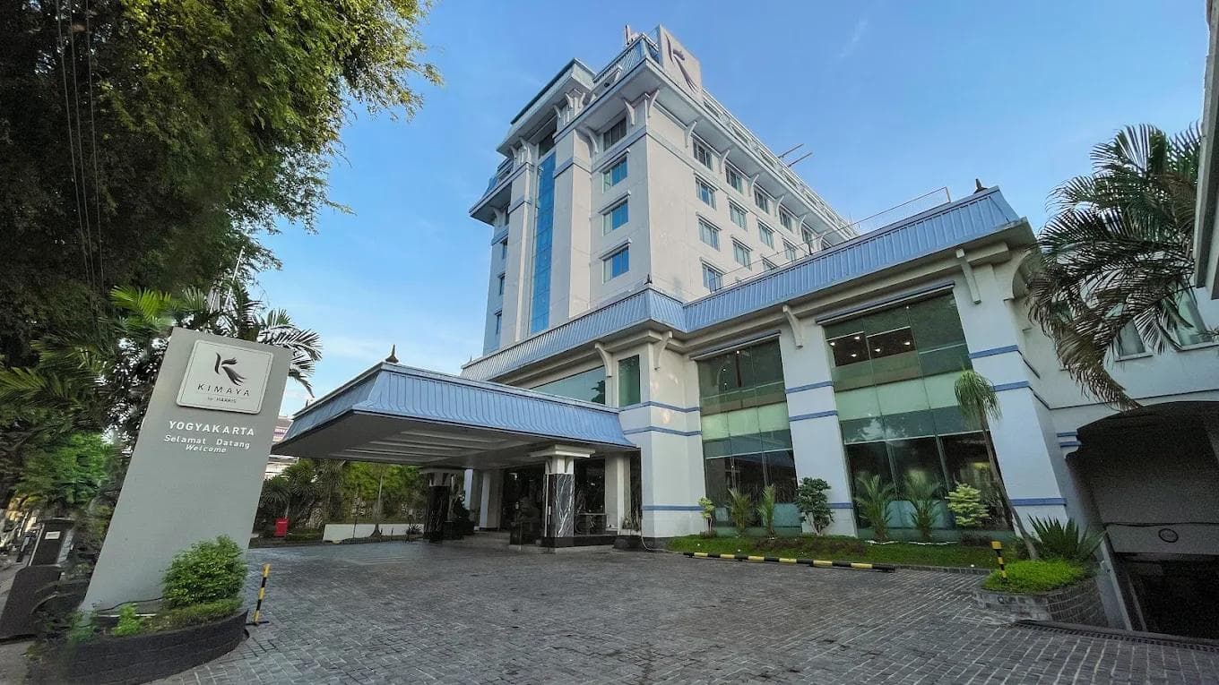 Exterior entrance and main building of Kimaya Sudirman Yogyakarta by Harris under a clear blue sky.