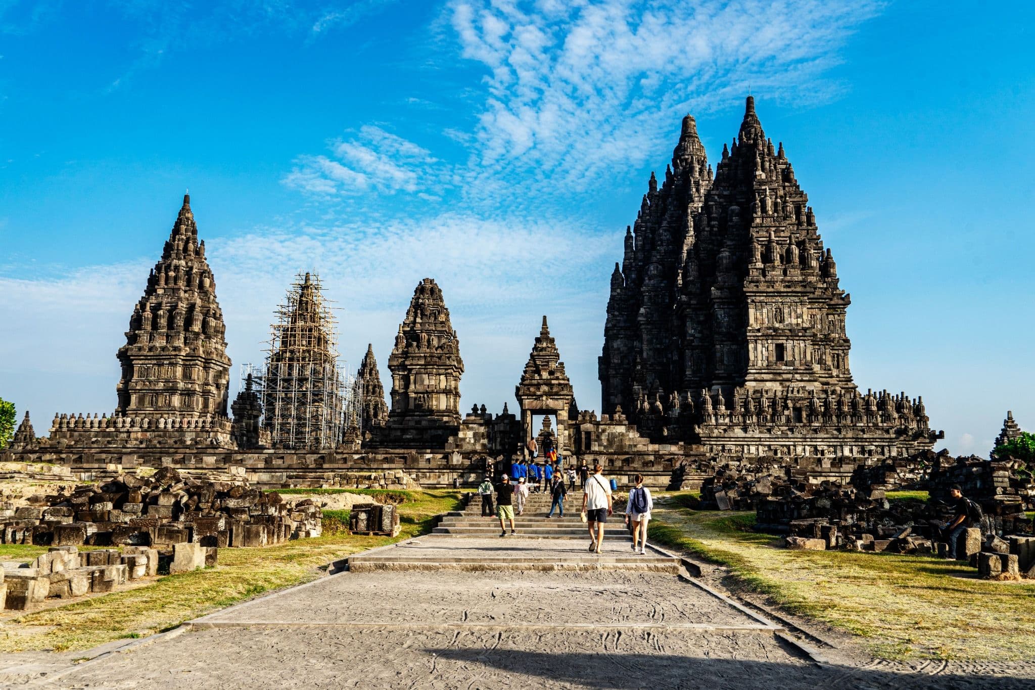 Prambanan Temple complex with towering stone temples beneath a bright blue sky.